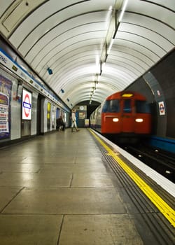 London, United Kingdom - November 25th, 2006: Victoria line tube train coming to Vauxhall station, passengers waiting on the platform.