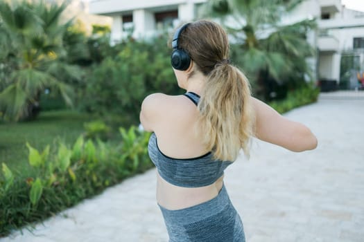 Young pretty smiling plus size woman in sporty top and leggings doing sport in summer outdoor