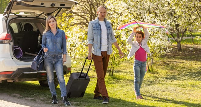 Happy family ready to go for a ride on their car