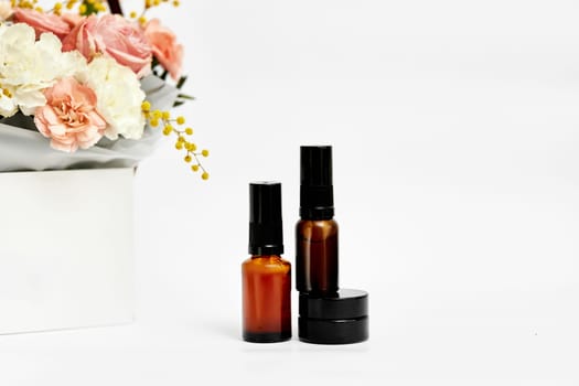 Small glass cosmetic bottle with natural ingredient and spring flower. natural concept