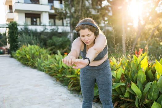 Young pretty smiling plus size woman in sporty top and leggings doing sport in summer outdoor