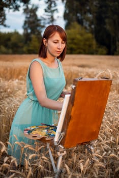 Female painter in turquoise dress meticulously painting details of the painting