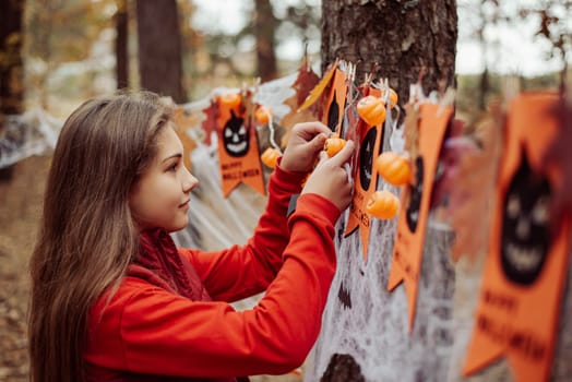 Little girl decorating place for celebrating Halloween in park