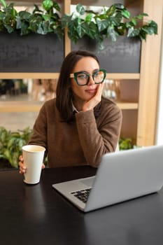 Distracted from work worried young woman sitting on desk with laptop, thinking of problems. Pensive unmotivated lady looking at monitor, feeling lack of energy, doing remote freelance tasks