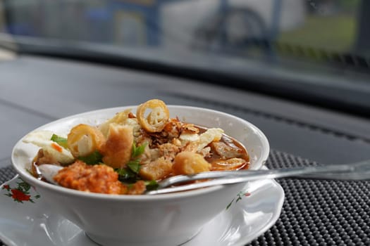 Soto Mie Bogor or Noodle soup with spring rolls from Bogor is authentic indonesian traditional food. Shot in the car.