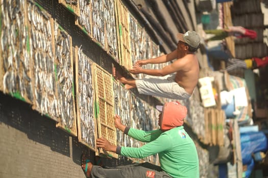 Banyuwangi, Indonesia - October 9, 2021 : People drying fish at the fishing port. Street Photography Editorial