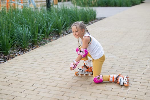 A little girl and her mom do a bridge exercise at the outdoor sports ground