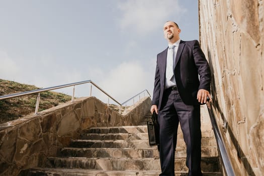 Business executive with briefcase going down the stairs.