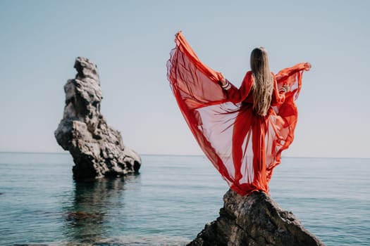 Woman travel sea. Happy tourist taking picture outdoors for memories. Woman traveler looks at the edge of the cliff on the sea bay of mountains, sharing travel adventure journey.