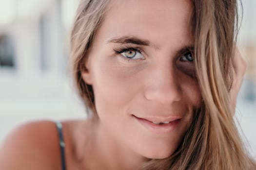 Happy woman portrait in cafe. Boho chic fashion style. Outdoor photo of young happy woman with long hair, sunny weather outdoors sitting in modern cafe