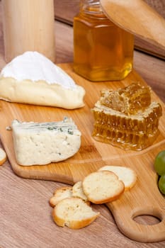 Healthy food. Differet type of cheese on wooden background. Gourmet delicatessen