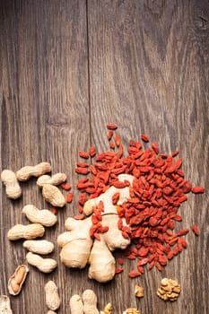 Raw organic food and nuts on wooden background. Over top view