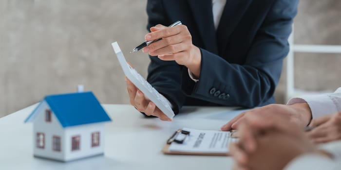 Happy couple signing a contract with real estate agent. renters tenants sign mortgage loan investment agreement or rental insurance contract meeting realtor lender landlord making real estate sale purchase deal.