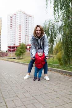 happy young mother walking with her little son in the park.