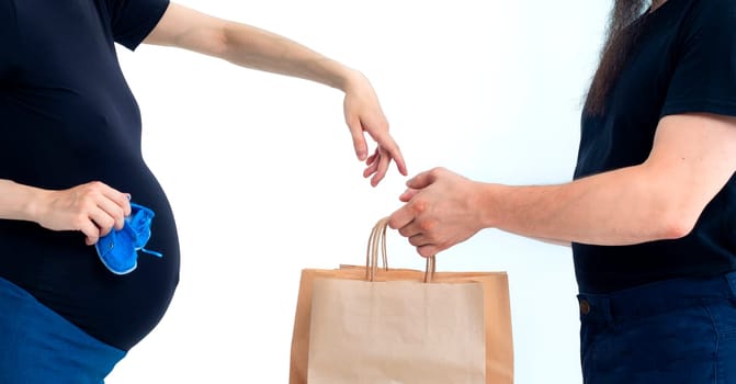 Portrait happy young pregnant woman and her husband with shopping bags and touching her big belly isolated on white background. Pregnancy shopping concept happy young family with shopping bags