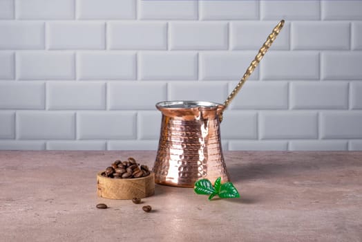 Traditional Turkish cezve, coffee pot, and coffee beans in a small wooden container. Selective focus.