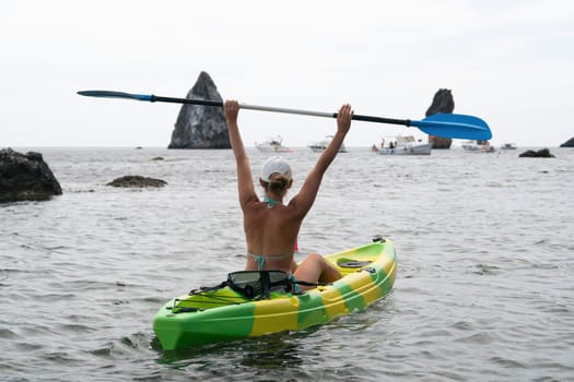 Kayaking. Travel adventure kayak on the tropical sea on a sunny day. Woman rowing a canoe.