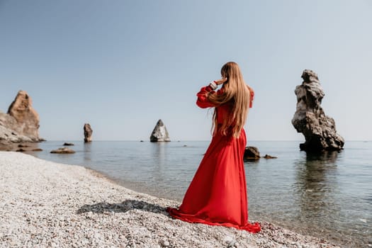 Woman travel sea. Happy tourist taking picture outdoors for memories. Woman traveler looks at the edge of the cliff on the sea bay of mountains, sharing travel adventure journey.