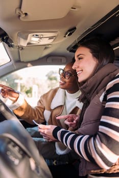 two young women in camper van planning road trip on the phone, concept of adventure and travel with best friend