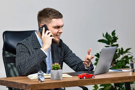 cheerful entrepreneur businessman working with laptop and talking on the phone