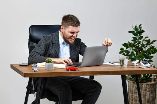 angry unhappy businessman shouting, reading bad news in email at laptop pc computer