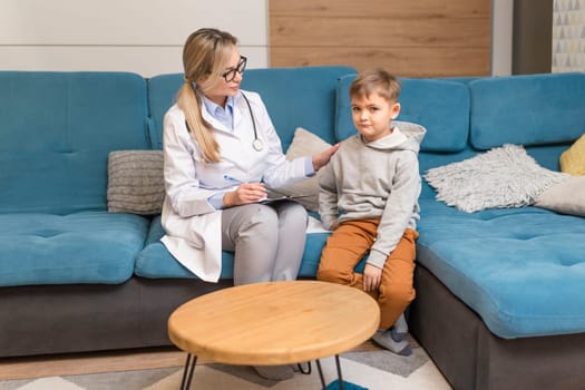 A family doctor examines a little boy at home. Pediatrician girl treats a child.