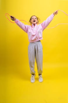 Adorable female child with skipping rope jumping in a studio