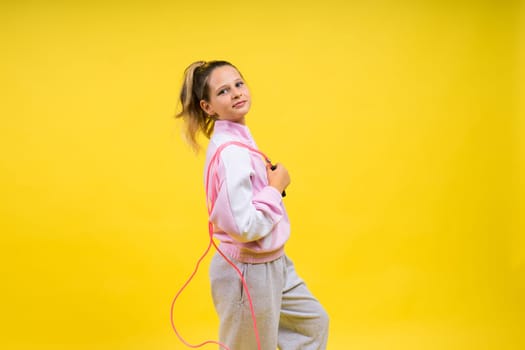 Adorable female child with skipping rope jumping in a studio