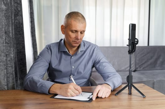 Businessman, psychologist communicates with the Internet audience using a smartphone. Video blogger broadcasts via smartphone.