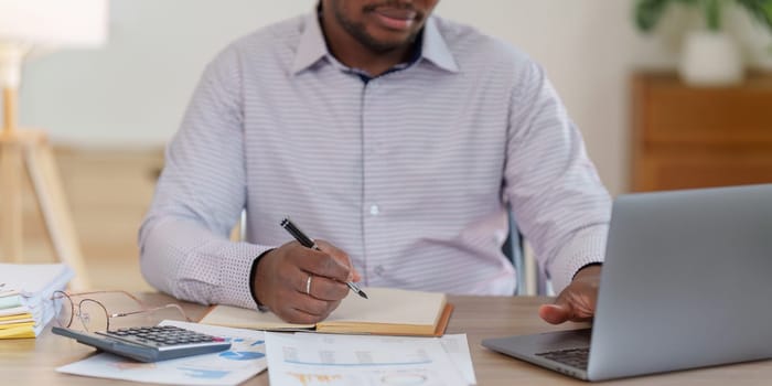 Smiling American African makes financial report and studies annual figures, analyzes profits. Accountant checks status of financial.