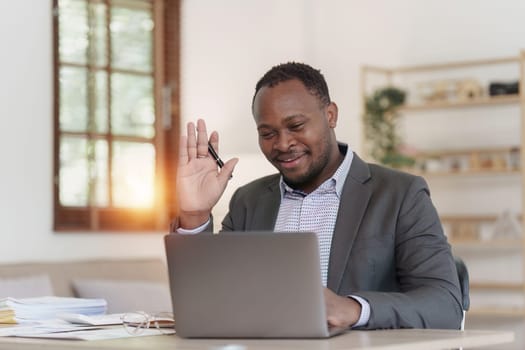 Smiling American African Banker or Accountant video call with client and makes financial report and studies annual figures, analyzes profits.