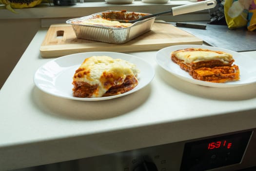Pieces of baked fresh lasagna on plates, food from the market