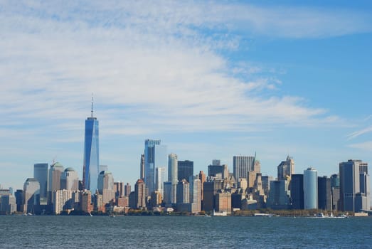 Gorgeous view of the Manhattan skyline with the Freedom Tower over a calm sea on a sunny day