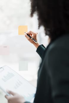 Beautiful young teen American African holding pen to note with planning working on financial document, tax, exchange, accounting and Financial advisor.