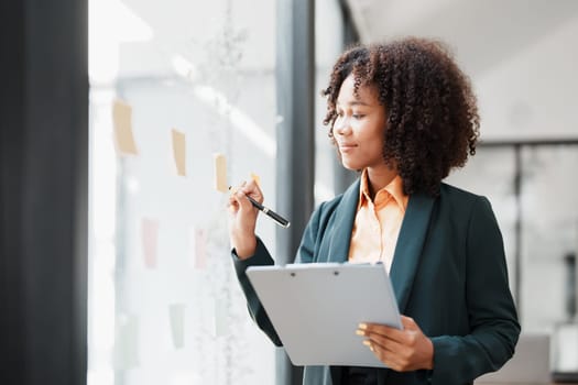 Beautiful young teen American African holding pen to note with planning working on financial document, tax, exchange, accounting and Financial advisor.