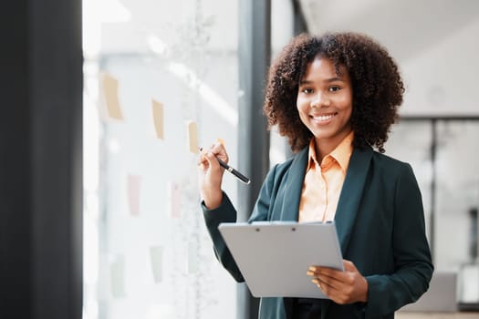 Beautiful young teen American African holding pen to note with planning working on financial document, tax, exchange, accounting and Financial advisor.