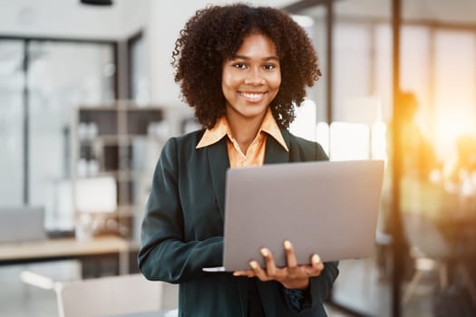 Beautiful young teen American African holding computer laptop with planning working on financial document, tax, exchange, accounting and Financial advisor.