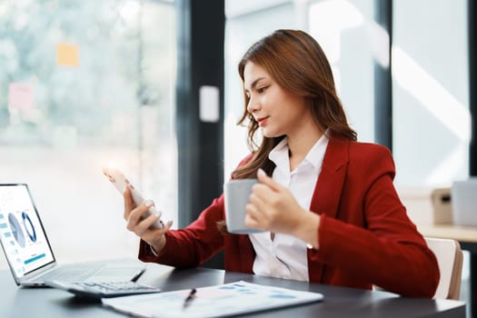 Beautiful young teen asian businesswoman using computer and smartphone mobile with planning working on financial document, tax, exchange, accounting and Financial advisor.