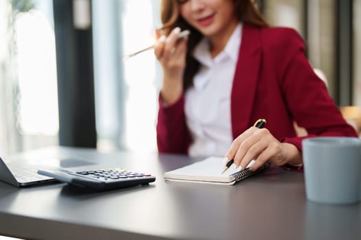 Beautiful young teen asian businesswoman using computer and smartphone mobile with planning working on financial document, tax, exchange, accounting and Financial advisor.