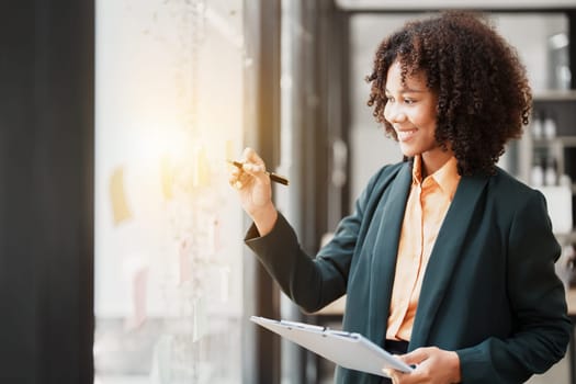 Beautiful young teen American African holding pen to note with planning working on financial document, tax, exchange, accounting and Financial advisor.