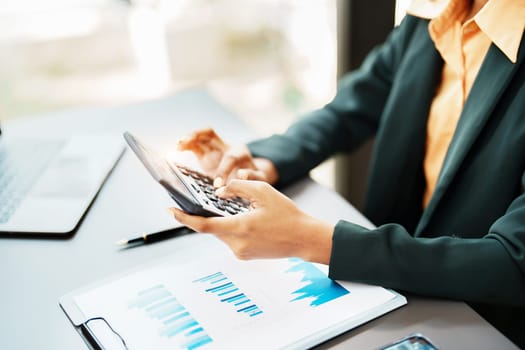 Beautiful young teen American African using calculator for calculating and computer laptop with planning working on financial document, tax, exchange, accounting and Financial advisor.