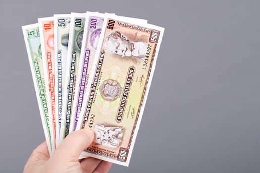 Old Peruvian money - Soles in the hand on a gray background