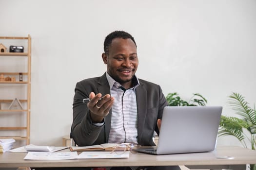 African American businessman using his laptop computer while working remotely from home. Online working or learning concept.