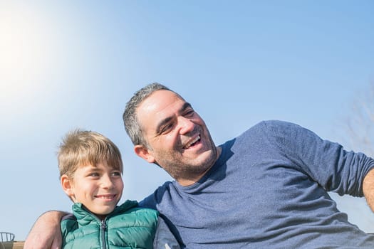 Happy smiling father and son against the blue sky. Family concept