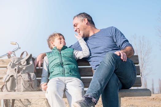 Happy smiling father and son against the blue sky. Family concept