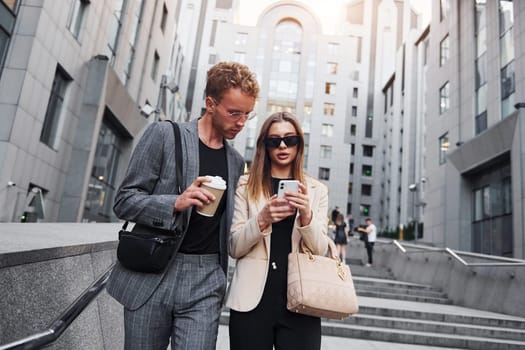 Woman and man in the town at daytime. Well dressed people.