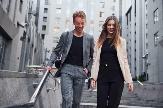 Woman and man in the town at daytime. Well dressed people.