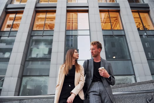 Woman and man in the town at daytime. Well dressed people.