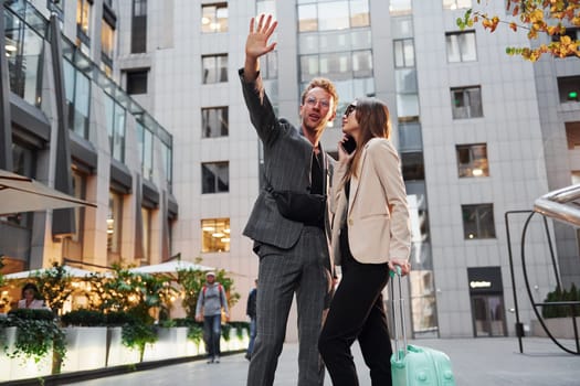 Beautiful business buildings. Woman and man in the town at daytime. Well dressed people.