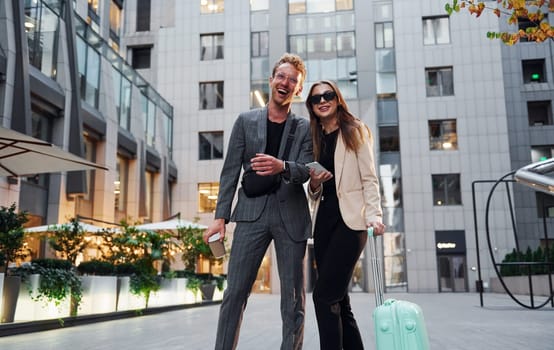 Beautiful business buildings. Woman and man in the town at daytime. Well dressed people.